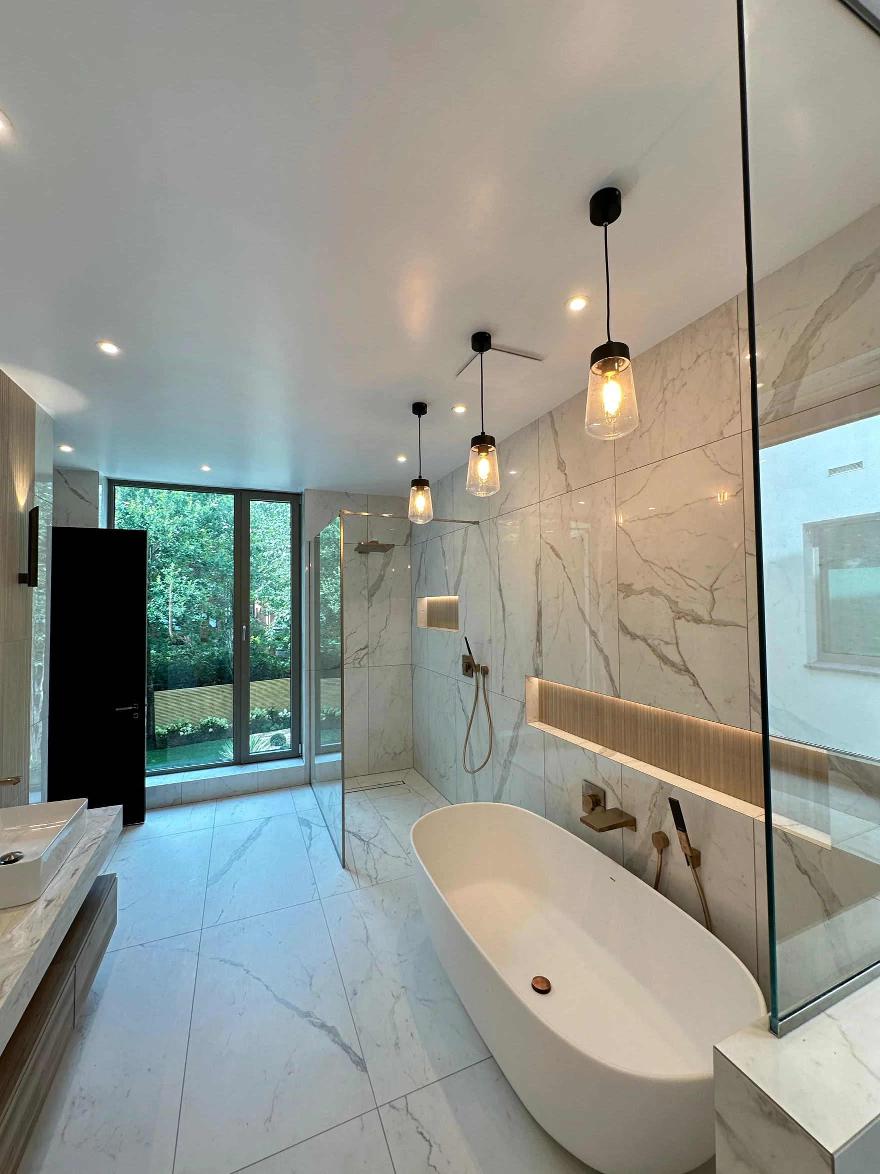 Contemporary marble-effect bathroom with freestanding bath