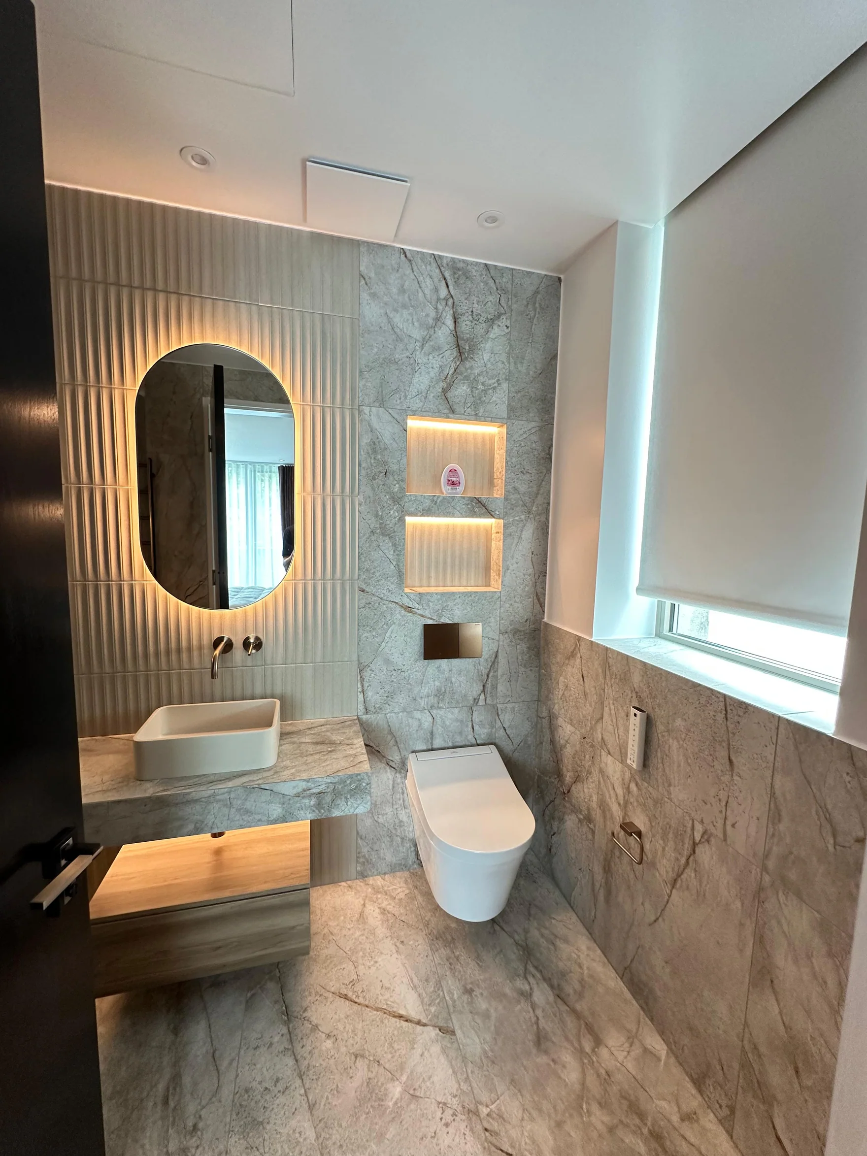 Floating vanity and warm illuminated niches